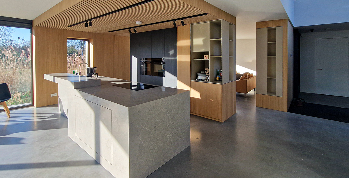 Maatwerk interieur met eikenhouten keuken, kastenwand en monoliet eiland in Rotterdam